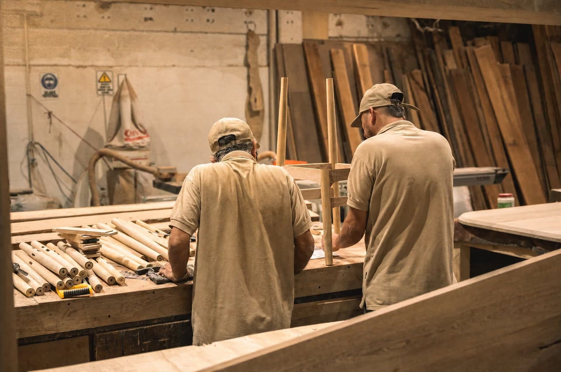 Dos carpinteros de Mowle ensamblando una silla de madera en el taller